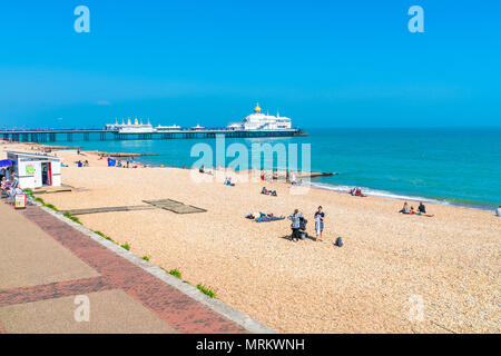 EASTBOURNE, Sussex, UK - Mai 20,2018: Menschen am Strand entspannen in Eastbourne, einem Badeort in East Sussex. Die Küste ist mit viktorianischen Uhr gefüttert Stockfoto