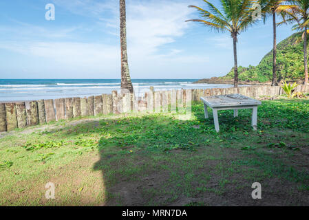 Tabelle durch einen Palm Tree Trunk Holz Zaun im Regenwald Strand Stockfoto