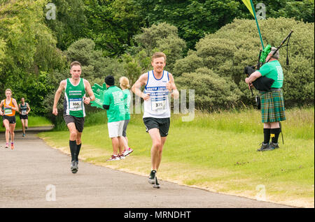 Edinburgh Marathon Festival, 26. Mai 2018. Gosford Estate, East Lothian, Schottland, Großbritannien. Marathonläufer an der Meile 18 mit Macmillan Cancer Charity stehen und Mann im Kilt Dudelsack spielen Stockfoto