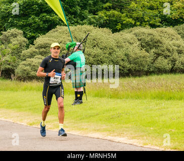 Edinburgh Marathon Festival, 26. Mai 2018. Gosford Estate, East Lothian, Schottland, Großbritannien. Marathonläufer an der Meile 18 mit Macmillan Cancer Charity stehen und Mann im Kilt Dudelsack spielen Stockfoto