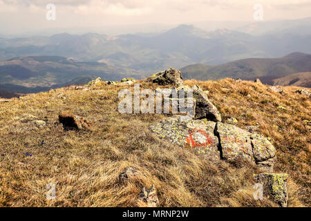 Malte Symbol auf einem Felsen Kennzeichnung ein Wanderweg auf dem Kopaonik Berg, Serbien. Rote und weiße Markierungen auf Felsen. Wegweiser für Wanderer. Farbe Effe Stockfoto