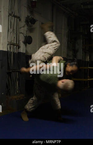 170622-M-GO 150-068 Cpl. Austin wirft Vilardi-Hawk Lance Cpl. Garett Verbrennungen beim Marine Corps Martial Arts Programm für die Ausbildung an Bord der USS Bonhmme Richard (LHD6) während in den Pazifischen Ozean, 22. Juni 2017 im Gange. Vilardi-Hawk ist ein militärischer Polizist und Martial Arts Instructor mit der Bekämpfung der Logistik Bataillon 31 und Verbrennungen ist ein Kampf Videofilmer mit dem 31 Marine Expeditionary Unit. MCMAP fördert die körperliche Eignung und Fähigkeiten schärft Marines im Nahkampf zu übergeben. Die 31. MEU Partner mit Amphibischen Squadron 11 der Marine den amphibischen Komponente von Bonhomme Richard Expedit zu bilden Stockfoto