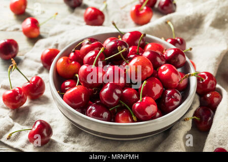 Rohe rote Bio Kirschen in eine Schüssel geben. Stockfoto