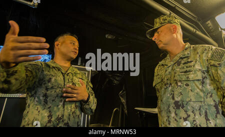 Hintere Adm. John korka, Kommandant der Marine Engineering Befehl Pacific, und Lt.Cmdr. Paul Duenas, an die in den Küstenzonen Riverine Group (CRG) 1 Ablösung Guam, Mk VI-Funktionen auf Naval Base Guam am 26. Juni 2017 erörtern. CRG 1 Loslösung Guam ist in der Lage, die Sicherheit des Seeverkehrs Operationen im gesamten Spektrum der Naval, Joint und Combined Operations. Weiter stellt es die zusätzlichen Möglichkeiten der Gefahrenabwehr, Sicherheit, Theater die sicherheitspolitische Zusammenarbeit und hohen Wert Einheit Schutz. (U.S. Marine bekämpfen Kamera Foto von Informationssystemen Techniker 1. Klasse Ledget Stockfoto