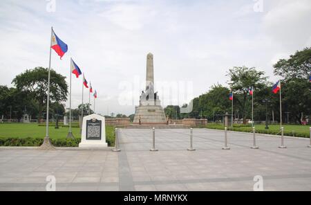 Ein Denkmal des philippinischen Helden Dr. Jose Rizal, flankiert von philippinischen Flaggen im Rizal Park in Manila. Stockfoto