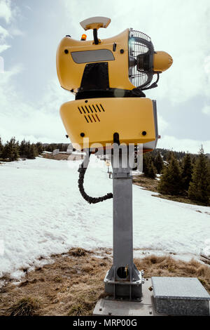 Schneekanone Maschine warten auf Frost mit Sun flare Hintergrund, Schneemaschine Maschine. Farbe Wirkung. Stockfoto