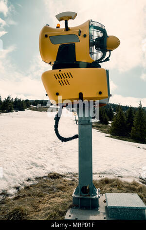 Schneekanone Maschine warten auf Frost mit Sun flare Hintergrund, Schneemaschine Maschine. Farbe Wirkung. Stockfoto