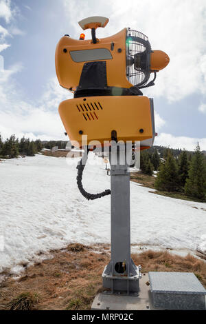 Schneekanone Maschine warten auf Frost mit Sun flare Hintergrund, Schneemaschine Maschine. Farbe Wirkung. Stockfoto