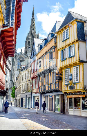 Pastellfarben Fachwerkhäuser und eine Kathedrale ragt in den Himmel gehören zu den Sehenswürdigkeiten in einer ruhigen Sonntag in Quimper, Bretagne, Frankreich. Stockfoto