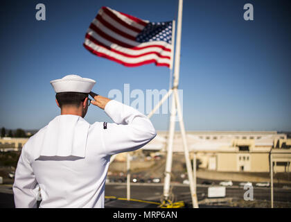 170627-N-LK571-108 SAN DIEGO (27. Juni 2017) Operations Specialist 3. Klasse Benjamin Kirkpatrick, der Flugzeugträger USS Carl Vinson (CVN-70) Color Guard zugewiesen salutiert die nationalen Ensign als es auf Halbmast zu Ehren der sieben Seeleute fliegt an Bord der geführte Flugkörper-Zerstörer USS Fitzgerald (DDG-62) verloren. Carl Vinson ist Expeditionary in seinem Heimathafen San Diego nach Abschluss einer fünf Monaten Einsatz im Westpazifik. (Foto: U.S. Navy Mass Communication Specialist 3. Klasse Matthew Granito/freigegeben) Stockfoto