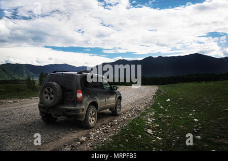 Offroad auto Konzept mit Berge. Das SUV im Vordergrund, auf dem Stein Straße von Kies. Stockfoto