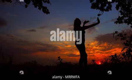 Weibliche silhouette Abend meditieren und Yoga im Sonnenuntergang Hintergrund. Stockfoto