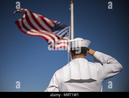 170627-N-LK571-079 SAN DIEGO (27. Juni 2017) Operations Specialist 3. Klasse Benjamin Kirkpatrick, zugewiesen auf dem Flugzeugträger USS Carl Vinson (CVN-70) Color Guard, salutiert die nationalen Ensign als es fliegt auf Halbmast zu Ehren der sieben Seeleute, die an Bord der geführte Flugkörper-Zerstörer USS Fitzgerald (DDG-62) bei einer Kollision auf See umgekommen sind. Carl Vinson ist Expeditionary an seinem Heimathafen in San Diego, Kalifornien, nach Abschluss einer fünfmonatigen Einsatz im Westpazifik. (Foto: U.S. Navy Mass Communication Specialist 3. Klasse Matthew Granito/freigegeben) Stockfoto