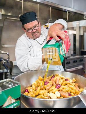 Maynard Oestreich, Executive Chef für Aramark Mahlzeiten bereitet vor der Flieger Führung Schulabschluss bei Travis Air Force Base, Calif., 28. Juni 2017. Oestreich einem ehemaligen US Navy Veteran und einem preisgekrönten Küchenchef aus Napa Valley, Calif., nahm der Küchenchef Position, so dass er Mentor junger Flieger könnte. (U.S. Air Force Foto von Louis Briscese) Stockfoto