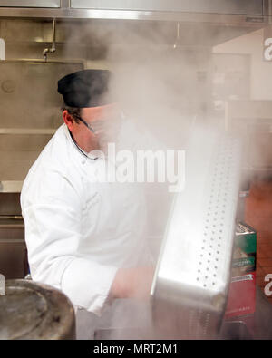 Maynard Oestreich, Executive Chef für Aramark Mahlzeiten bereitet vor der Flieger Führung Schulabschluss bei Travis Air Force Base, Calif., 28. Juni 2017. Oestreich einem ehemaligen US Navy Veteran und einem preisgekrönten Küchenchef aus Napa Valley, Calif., nahm der Küchenchef Position, so dass er Mentor junger Flieger könnte. (U.S. Air Force Foto von Louis Briscese) Stockfoto