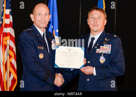 Gen. Mike Holmes, Commander, Air Combat Command, präsentiert pensionierter Luftwaffe Oberstleutnant Gregory Thornton mit der Silver Star Medaille im Rahmen einer Feierstunde im Nationalen Museum der United States Air Force in Dayton, Ohio, 30. Juni 2017. Thornton erhielt den Silver Star für seine Aktionen am 6. April 2003 Während die "33", das Rufzeichen für ein Forward air Controller zu Task Force 2nd Battalion, 69th Armor, während der Kampfhandlungen im Irak. Der Silver Star ist der dritthöchste bekämpfen Dekoration für galanterie in Aktion, die an ein Mitglied der Unite gewährt werden kann Stockfoto