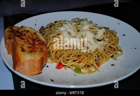 Spaghetti Carbonara mit Parmesan und Scheibe Knoblauchbrot auf einer weißen Platte Stockfoto