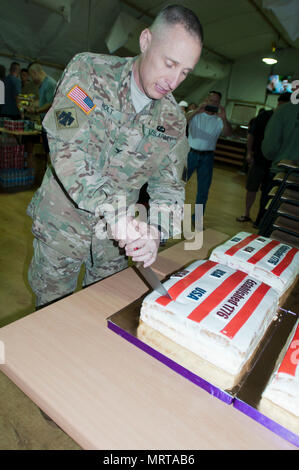 Colonel Elmer Holt, Stabschef der Gemeinsame Multinationale Ausbildung Group-Ukraine und der US Army 45th Infantry Brigade Combat Team, Feierlich schneidet den Kuchen, während Soldaten mit der 45th IBCT das Viertel von Juli feiern mit einer Grillparty und verschiedenen sportlichen Veranstaltungen an der Yavoriv Combat Training Center auf dem internationalen Friedens und der Sicherheit, in der Nähe der Yavoriv, der Ukraine, der am 4. Juli. Der 45 IBCT ist in der Ukraine als Teil des Gemeinsamen multinationalen Ausbildung Group-Ukraine, eine internationale Koalition für eine Verbesserung der Ausbildung der Fähigkeit des CTC und Gebäude professionali bereitgestellt Stockfoto