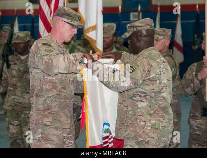 Oberst Stephen M. Bousquet, Kommandeur der 369th Sustainment Brigade von der New York Army National Guard und Command Sergeant Major Anthony Mclean, eingetragenen Berater von der 369th Fall die Brigade Farben während einer Übertragung von Autorität Zeremonie im Camp Arifjan, Kuwait, 26. Juni 2017. 369th SB aufgegeben Befehl Sustainment Operationen der 371. Sustainment Brigade aus Ohio National Guard. (Foto: US-Armee Sgt. Jeremy Bratt) Stockfoto