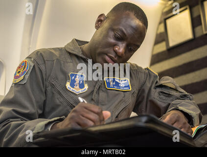 Tech. Sgt. Anthony Montgomery, 201St Airlift Squadron Flight Attendant, nimmt Pre-flight Noten vor einer Mission Readiness Luftbrücke am Joint Base Andrews, Md., 31. März 2017. Die 201St als unterstützt eine fliegende Zeitplan bestehend aus etwa fünf große Reisen ein Monat, von 5 auf 12 Tage und fast überall auf der Welt gehen. (U.S. Air Force Foto von älteren Flieger Jordyn Fessel) Stockfoto