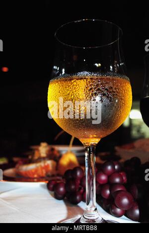 Kalte Weißwein serviert in einem Glas Wein mit Feuchtigkeit in einer Tabelle einstellen Stockfoto