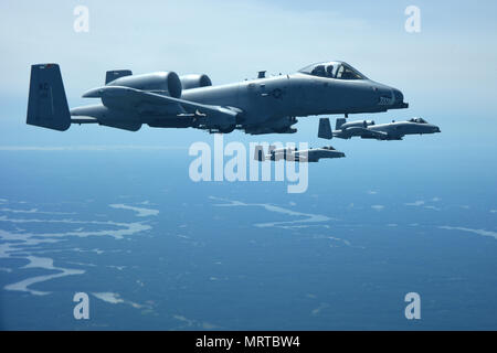 Drei der A-10 Thunderbolt II, Whiteman Air Force Base, Calif. zugeordnet, fliegen neben einer KC-135 Stratotanker nach dem Tanken, 30. Juni 2017. Die A-10 zu warfighters auf dem Boden in der Nähe air Support bieten, aber tanken Mitte Flug aufgrund seiner begrenzten Strecke benötigen. (U.S. Air Force Foto/Älterer Flieger Chris Thornbury) Stockfoto