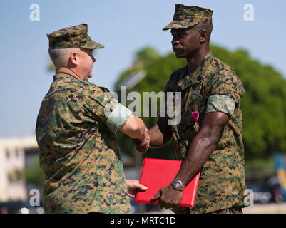 Us Marine Corps Sgt. Maj. Delvin R. Smythe, der Marine Corps Air Station (WAB) Yuma, Ariz., Sergeant Major, erhält Auszeichnungen von Col. Ricardo Martinez, der scheidende Kommandeur der WAB Yuma und Master Gunnery Sgt. Arthur Parra, der amtierende Sergeant Major der WAB Yuma, während der Sgt. Maj. Der smythe Ruhestand Festakt, 30. Juni 2017. (U.S. Marine Corps Foto von Lance Cpl. Joel Soriano) Stockfoto