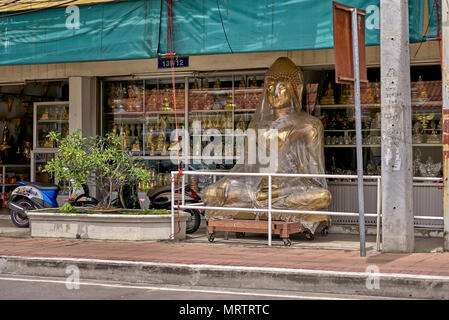 Buddha mit Plastikfolie. Statue in Plastik verpackt und als Werbefigur in einem buddhistischen Geschäft in Thailand tätig. Südostasien Stockfoto