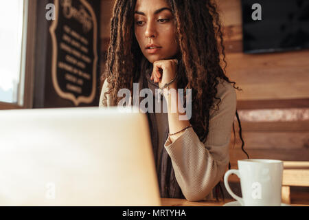 Nahaufnahme von einer Frau an einem Tisch im Restaurant sitzen Arbeiten am Laptop. Freelancer im Cafe sitzen und einen Kaffee Arbeiten am Laptop. Stockfoto