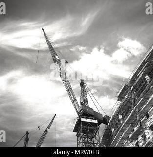 1960, historische, Blick vom Boden bis zu einem McAlpine Kran hoch in den Himmel schauen. In dieser Ära, London erleben Sie einen Bauboom als post-ww2 Bombe Websites und beschädigte Gebäude wurde in riesige Beton Turm und Bürogebäude umgebaut. Die McAlpine Bauunternehmen - Sir Robert McAlpine - war immer vorhanden und renommierten Namen im Bau mit Wembley Stadion und dem Dorchester Hotel zwischen den Kriegen. Stockfoto