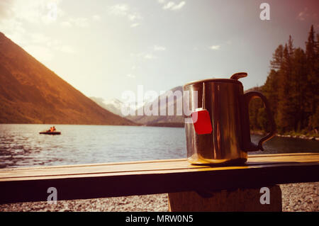 Russland, Altai, Kararol Seen, Fluss Katun. Travel thermo Tasse mit Tee inmitten der wunderschönen Seen und hohen Bergen Stockfoto