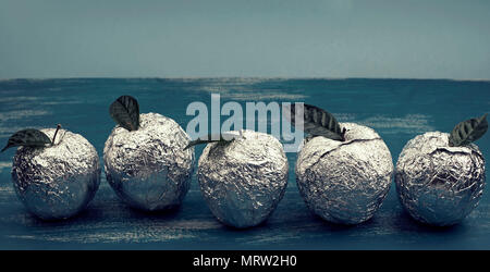 Banner fünf Äpfel in der shell Folie mit natürlichen grünen Blättern. Holz- candy blauen Hintergrund. Flach Top View Stockfoto