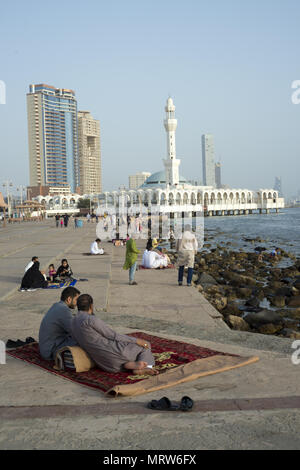 Zwei Männer auf einem Teppich auf der Corniche in der Nähe der berühmten Moschee in Jeddah, Saudi-Arabien Stockfoto