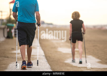 Senior Paar Nordic waling am Strand. Stockfoto