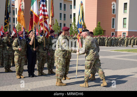 Oberst James B. Bartholomees III (links), eingehende Kommandant der 173Rd Airborne Brigade erhält die Brigade Farben von Generalmajor Timothy S. McGuire (Mitte), dem Stellvertretenden Kommandierenden General, U.S. Army Europe, während der Befehl Zeremonie an Caserma Del Din in Vicenza, Italien, 7. Juli 2017. Die 173Rd Airborne Brigade, in Vicenza, Italien, ist die Armee Contingency Response Force in Europa, und ist in der Lage, Kräfte projizieren die vollständige Palette der militärischen Operationen in den Vereinigten Staaten der Europäischen, Zentralen und Verantwortungsbereiche afrikanischen Befehle durchzuführen. (U.S. Armee Foto von Visu Stockfoto