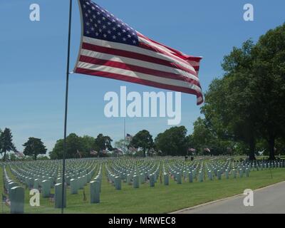 Eine grosse United Flaggenstaaten zum halben Personal und kleinen US-Flaggen im Wind am Fort Gibson National Cemetery in Muskogee, Oklahoma Stockfoto