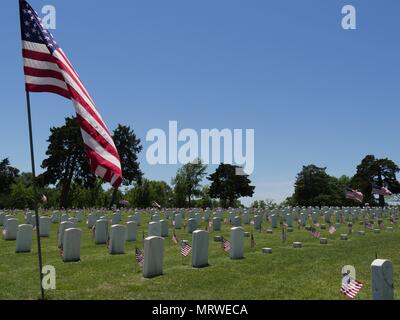 Eine grosse United Flaggenstaaten und kleinen US-Flaggen neben die Grabsteine an der Fort Gibson National Cemetery in Muskogee, Oklahoma Stockfoto