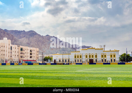 Kleiner Fußballplatz in Maskat, Oman, mit Gebäuden und die Berge im Hintergrund. Stockfoto