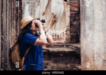 Asiatische tourist Frau unter Foto des alten Thailändischer Tempelarchitektur in Sukhothai Historical Park, Thailand. Weibliche Reisende im casual Thai Mauhom s Stockfoto