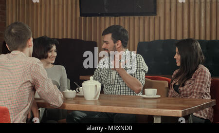 Gruppe von Jugendlichen in einem Café sitzen, reden und genießen. Professionelle Aufnahme in 4K-Auflösung. 088. Sie können es verwenden, z. B. in ihrem kommerziellen Video, Stockfoto