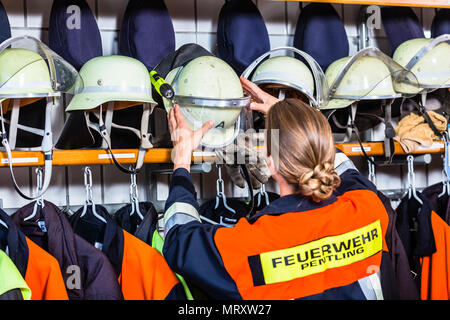 Weibliche fire fighter in der Umkleide, Helm Stockfoto