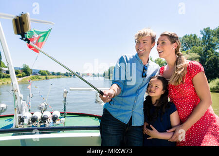 Familie auf Flusskreuzfahrt mit selfie Stick im Sommer Stockfoto