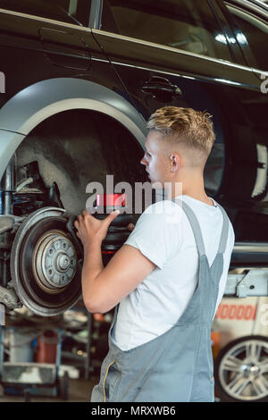 Erfahrener Mechaniker Austauschen der Festplatte Bremsen eines Autos in einer modernen Werkstatt Stockfoto