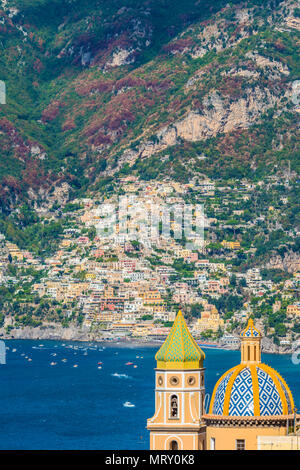 Praiano, Amalfi, Salerno, Kampanien, Italien. Die Kirche von Praiano mit Positano Dorf im Hintergrund Stockfoto