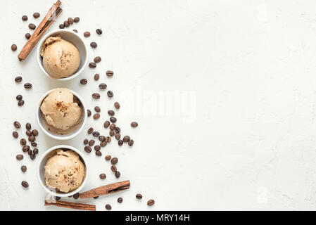 Kaffee Eis auf weißem Hintergrund, Ansicht von oben. Gefrorenen Kaffee gelato Eis mit Kaffeebohnen und Zimt - gesunde Sommer Nachtisch. Stockfoto
