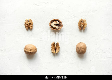 Walnüsse auf weißem Hintergrund mit Muscheln und als Muster geschält, flach mit Kopie Raum legen. Stockfoto