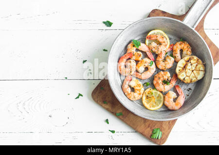 Gebratene Garnelen mit Zitrone, Knoblauch und Kräutern. Meeresfrüchte, shelfish. Garnelen vom Grill mit Gewürzen, Knoblauch und Zitrone auf weißem Hintergrund, kopieren. Stockfoto