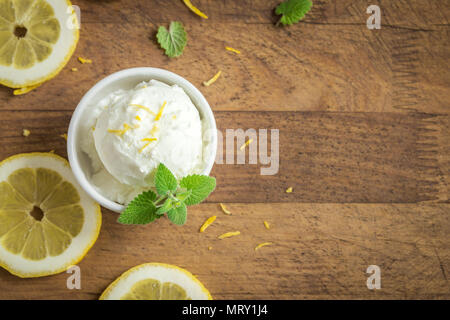 Lemon Ice Cream in der Schüssel. Hausgemachte citrus Lemon Ice Cream (Gelato) mit Minze. Stockfoto