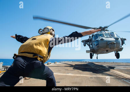 170710-N-MU 198-088 MITTELMEER (10 Juli 2017) Personal Specialist 2. Klasse Andre Pangkerego führt eine MH-60S Sea Hawk Hubschrauber auf dem Flight Deck an Bord der geführte-missile Cruiser USS philippinischen Meer (CG58). Das Schiff ist Teil der George H.W. Bush Carrier Strike Group, die Durchführung von naval Operations in den USA 6 Flotte Bereich der Maßnahmen zur Unterstützung der US-amerikanischen nationalen Sicherheitsinteressen in Europa und Afrika. (U.S. Marine Foto von Mass Communication Specialist 3. Klasse Danny Ray Nunez Jr./Freigegeben) Stockfoto