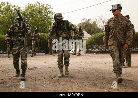 Cpl. Robert Piedra, ein rifleman mit speziellen Zweck Marine Air-Ground Task Force - Krisenmanagement - Afrika, rechts, überwacht die Geschwindigkeit laden Rennen zwischen zwei Mitglieder des senegalesischen Compagnie Füsilier de Marin Commando während einer 4-wöchigen Ausbildung Übung an Toubakouta, Senegal, 14. April 2017. Marines mit SPMAGTF-CR-AF und der COFUMACO ein vierwöchiges Training, Advanced combat Brenntechniken, einem Maschinengewehr Reichweite und eine Live-fire Platoon Angriff Angebot durchgeführt. Stockfoto